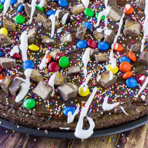 A closeup image of brownie dessert pizza on the table ready to serve adn eat.