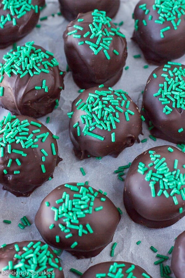 Mint oreo balls are placed next to each other on a sheet of parchment paper.
