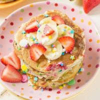 Strawberry Banana Protein Pancakes- Light & fluffy protein buttermilk pancakes filled with strawberries, bananas and sprinkles that not only taste delicious but keep you full until lunch!