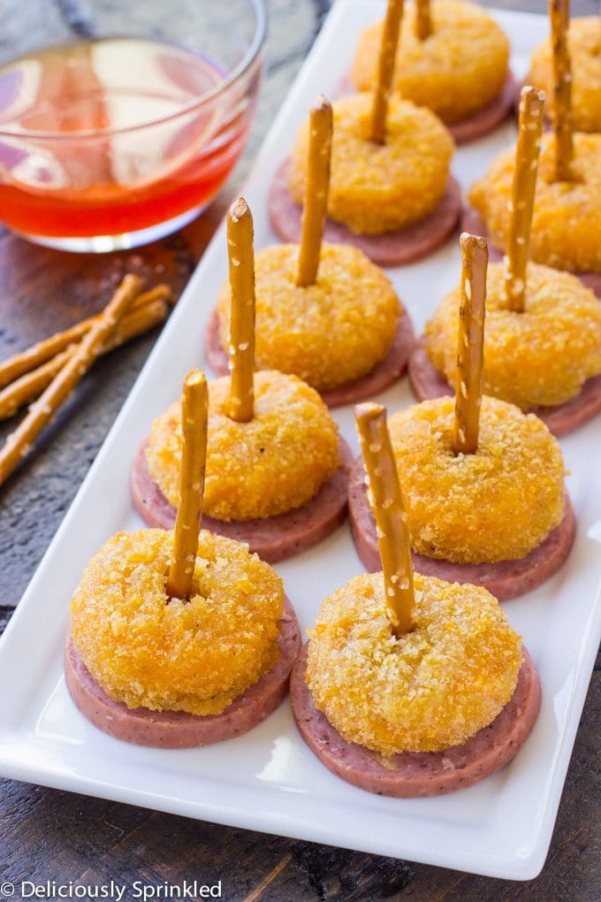 Pimento Cheese and Sausage Bites delicious summer sausage topped with a crispy Pimento Cheese Bite that’s easy to eat with a pretzel stick, making these an easy to eat holiday party appetizer.