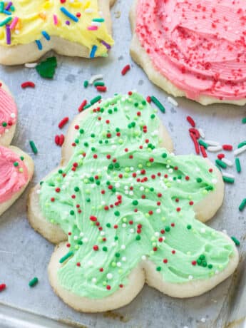 Traditional Christmas Cookies with frosting and sprinkles on a baking pan.