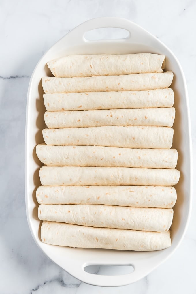 rolled up tortillas in a pan for easy chicken enchiladas