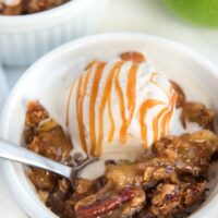 apple crisp topped with ice cream with spoon