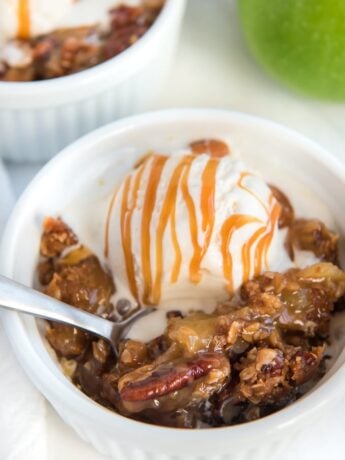 apple crisp topped with ice cream with spoon