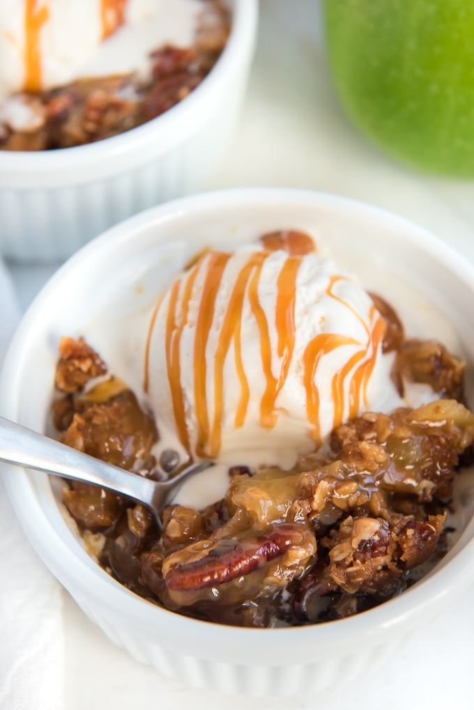 apple crisp topped with ice cream with spoon