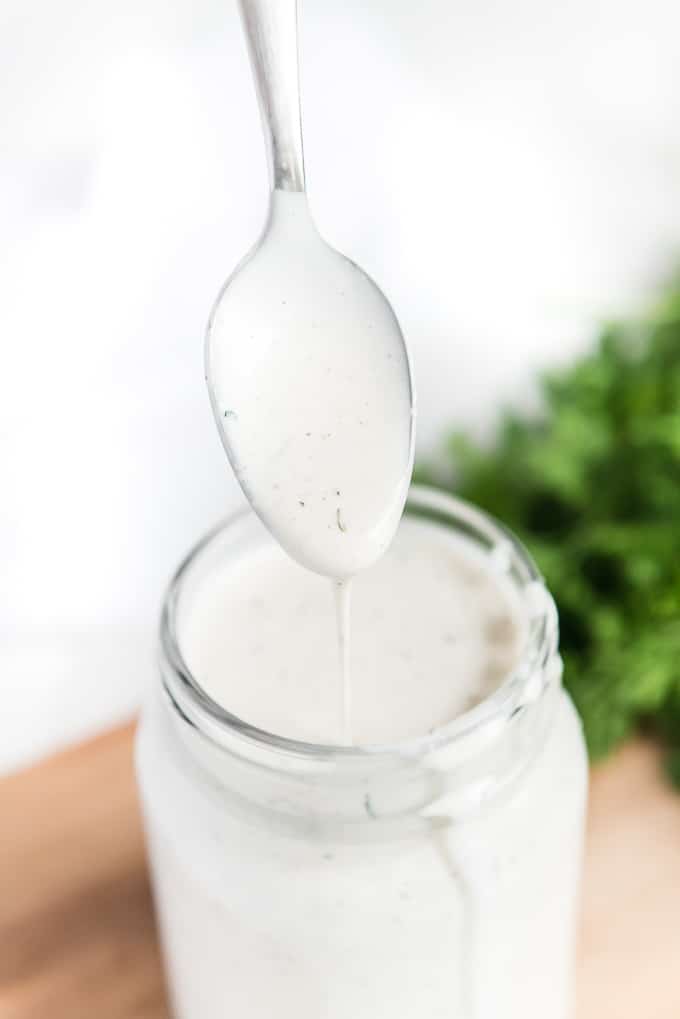 ranch dressing in mason jar while dripping off spoon