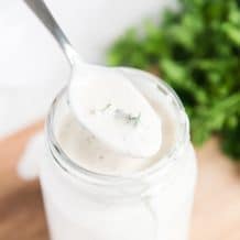 ranch dressing in mason jar while holding spoon over