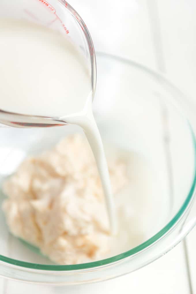 pouring buttermilk into bowl of ranch dressing ingredients