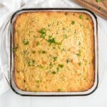 A Jiffy corn casserole baked in a dish and sprinkled with green onions.