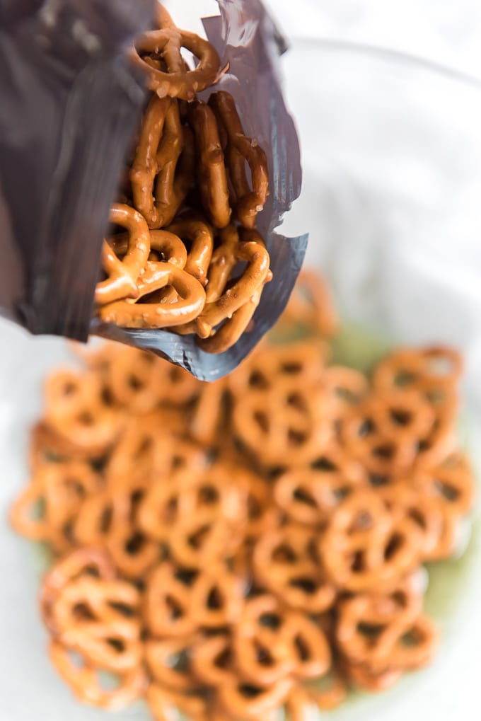 pouring a bag of pretzels into a mixing bowl