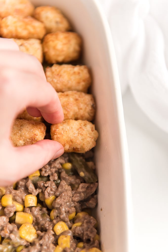 layering tater tots on top of tater tot casserole