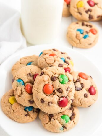 Cookies are presented in a stack on a white plate next to a glass of milk.