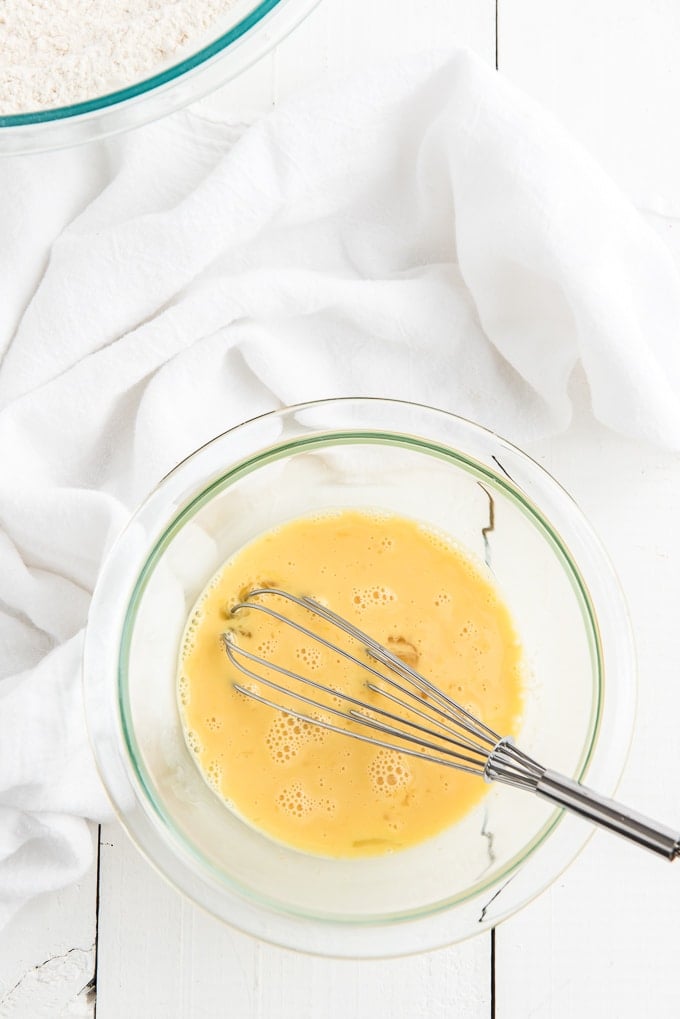 Wet ingredients have been whisked in a glass bowl. 