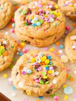 Vanilla cookies are covered in pastel rainbow sprinkles.