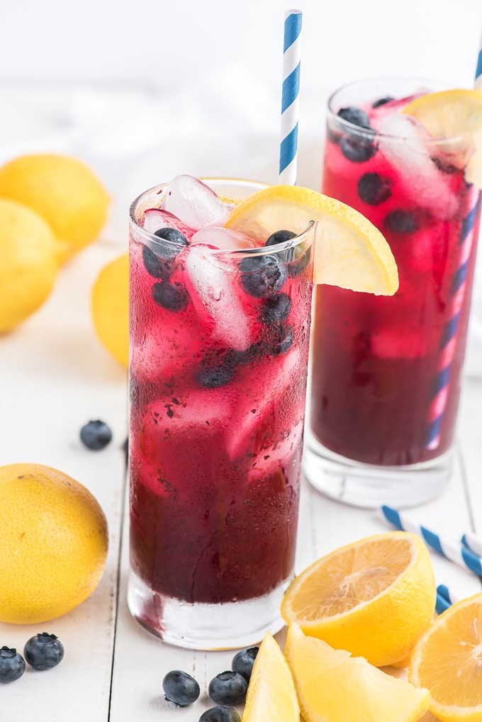 two glasses of blueberry lemonde topped with blueberries and fresh lemon slice