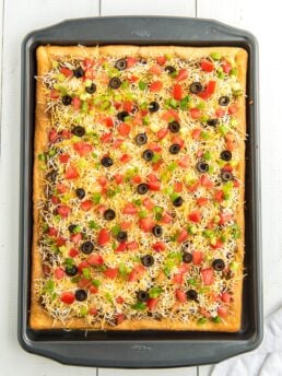 taco pizza topped with fresh tomatoes and olives