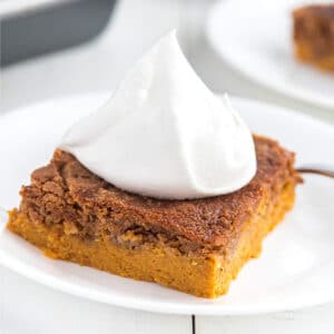 pumpkin cake with cake mix on a plate topped with whipped cream.