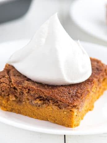 pumpkin cake with cake mix on a plate topped with whipped cream.