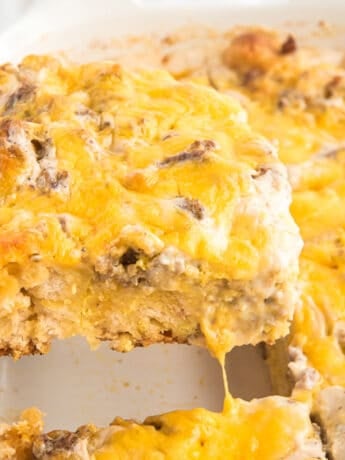 A spatula lifting out a square of easy breakfast casserole from the pan to serve.