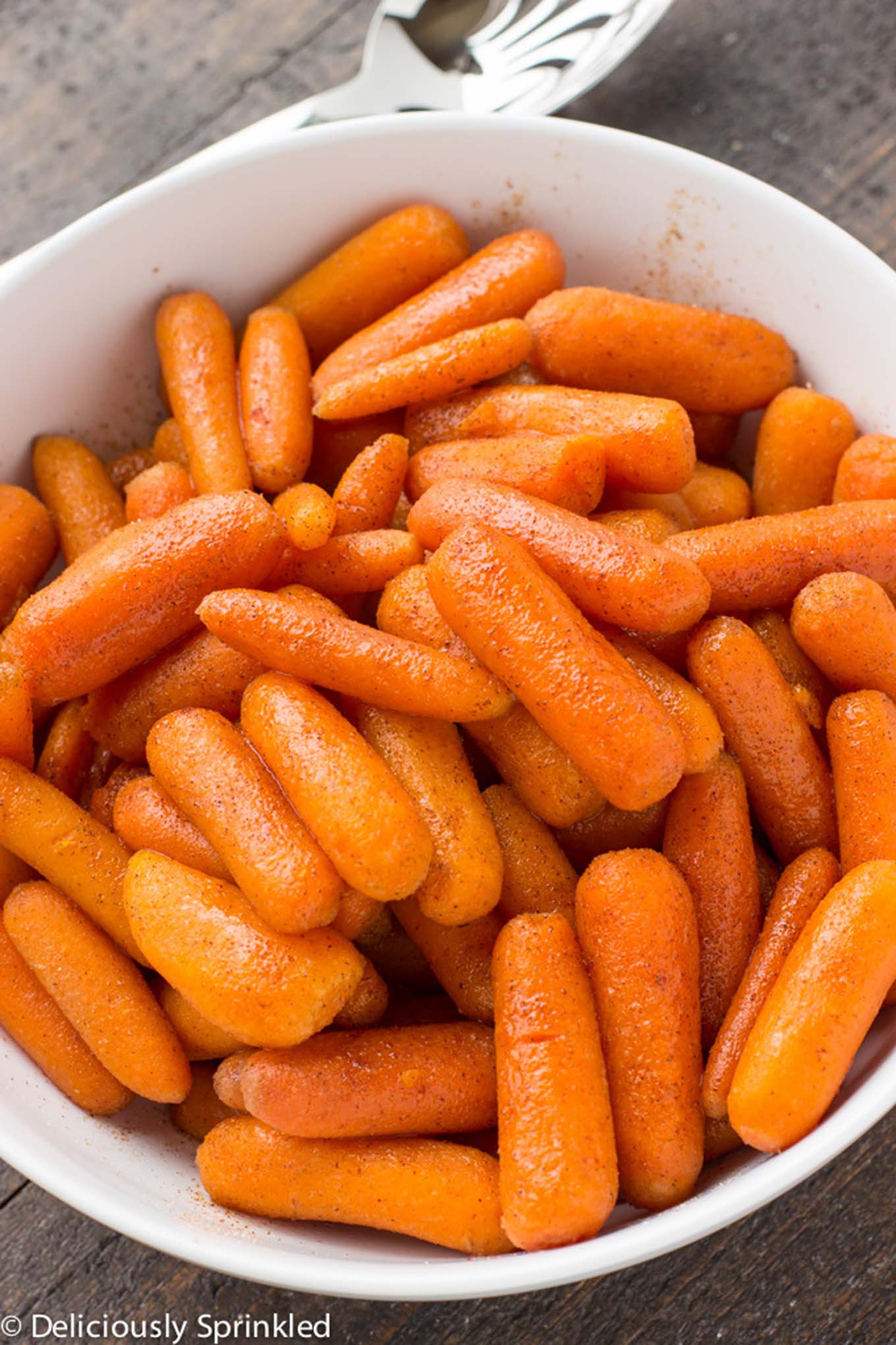 A bowl of brown sugar carrots in a bowl on the table.