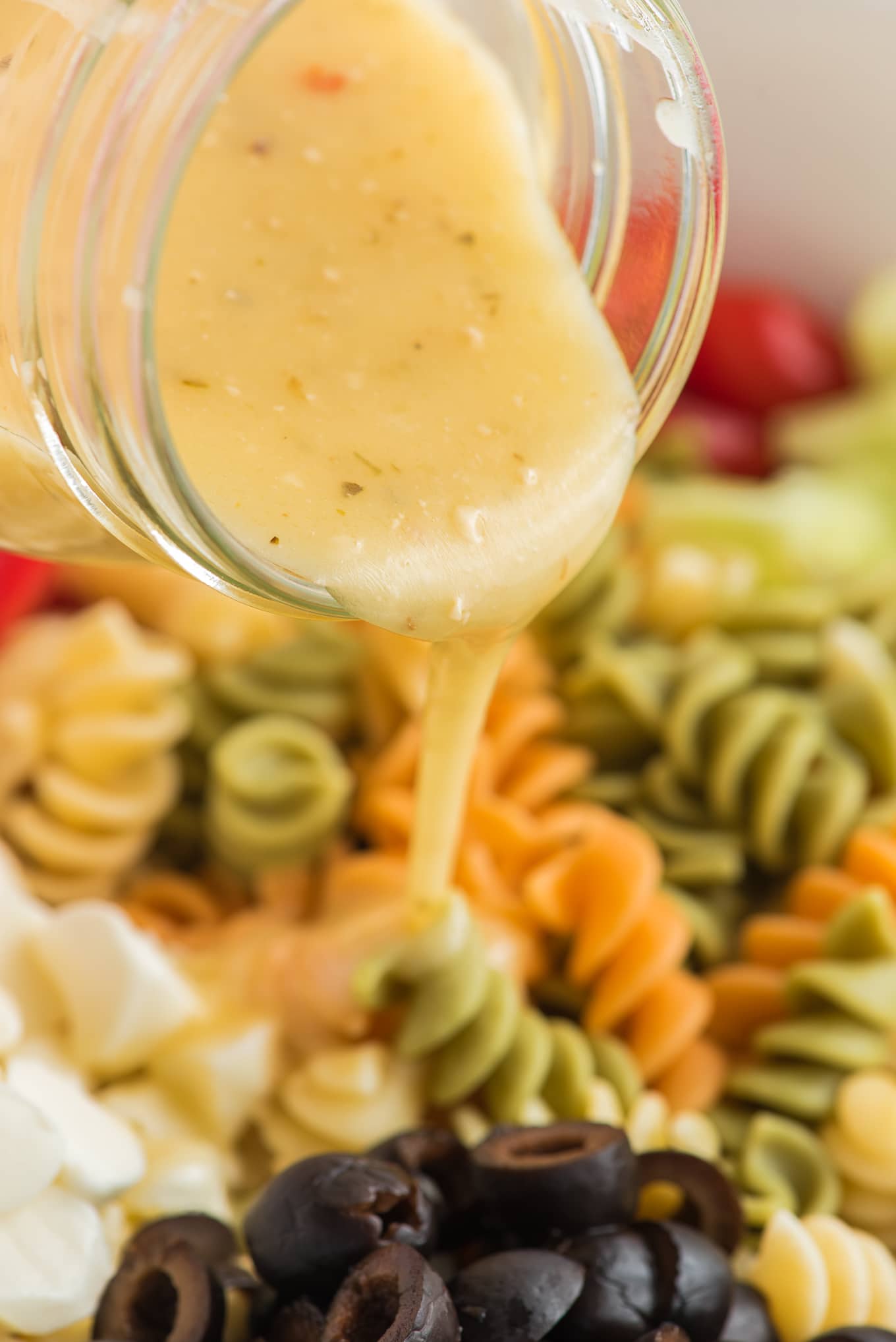 Olive Garden Dressing on pasta salad / Easy Pasta Salad is the best cold pasta salad with tri color pasta, tomatoes, cucumbers, onions, and mozzarella cheese tossed in olive garden Italian dressing. 