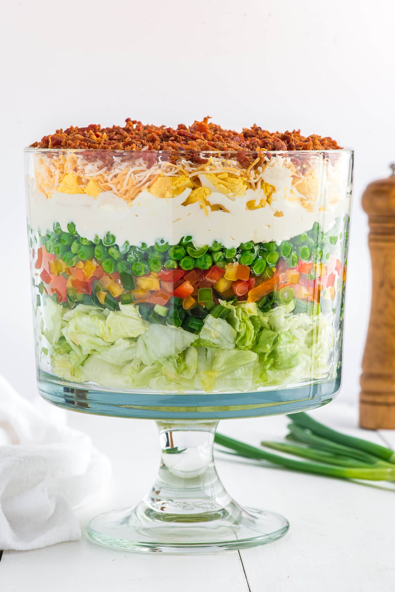 Front view of a 7 layer salad in a trifle bowl.