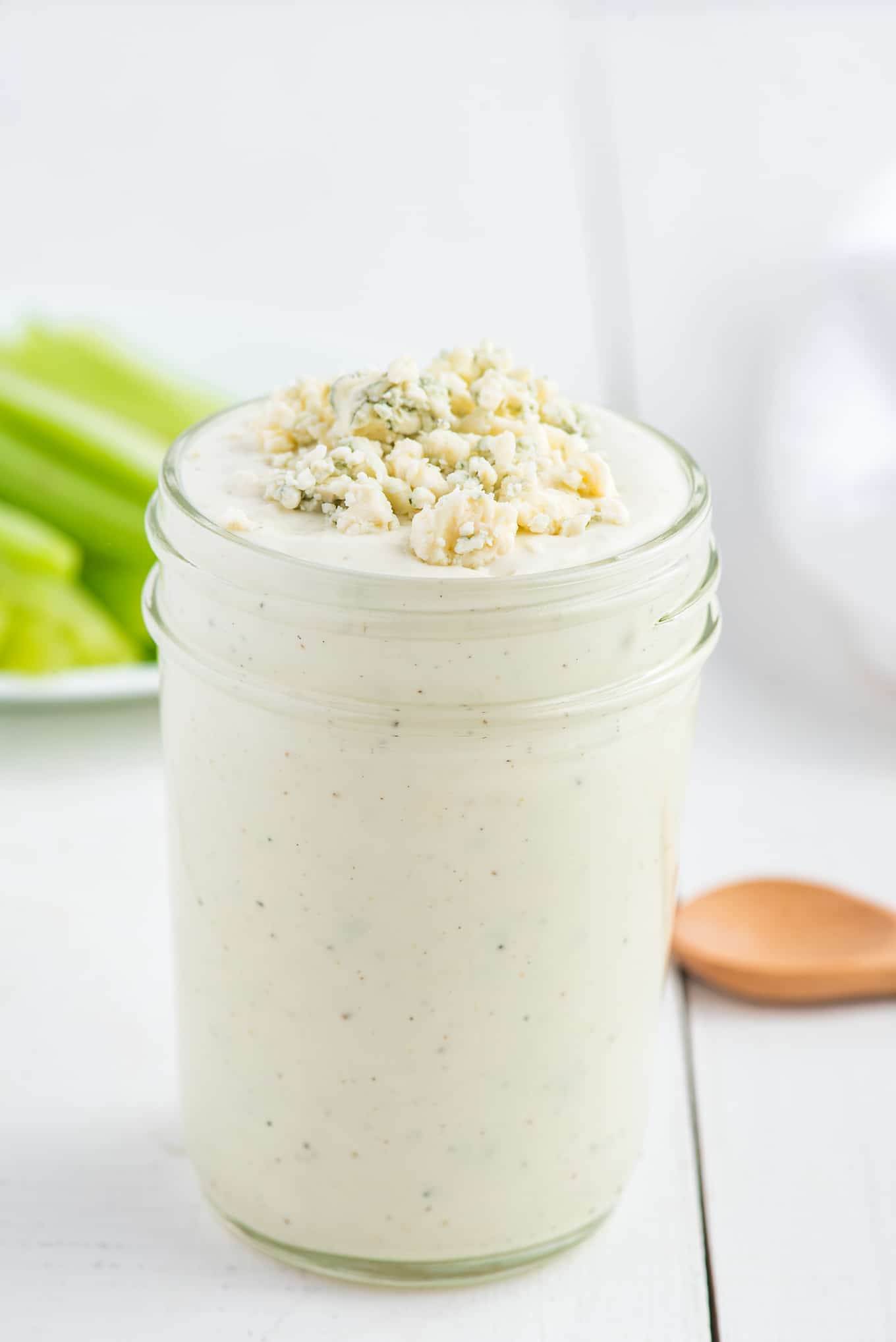 Dressing in a glass jar with blue cheese crumbles on top.