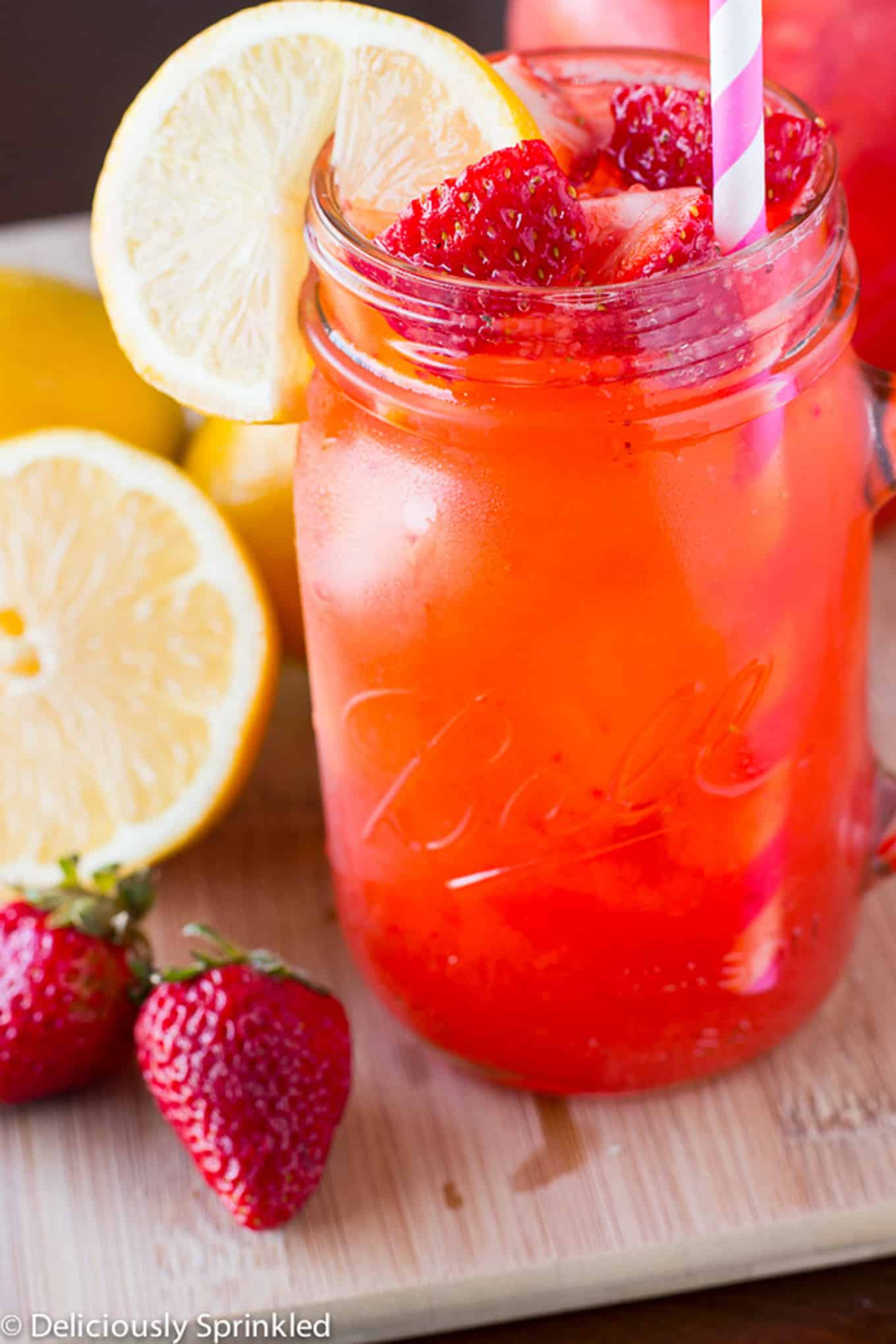 Strawberry Lemonade in a mason jar with straw. / Fresh strawberry lemonade made with only 4 simple ingredients. 