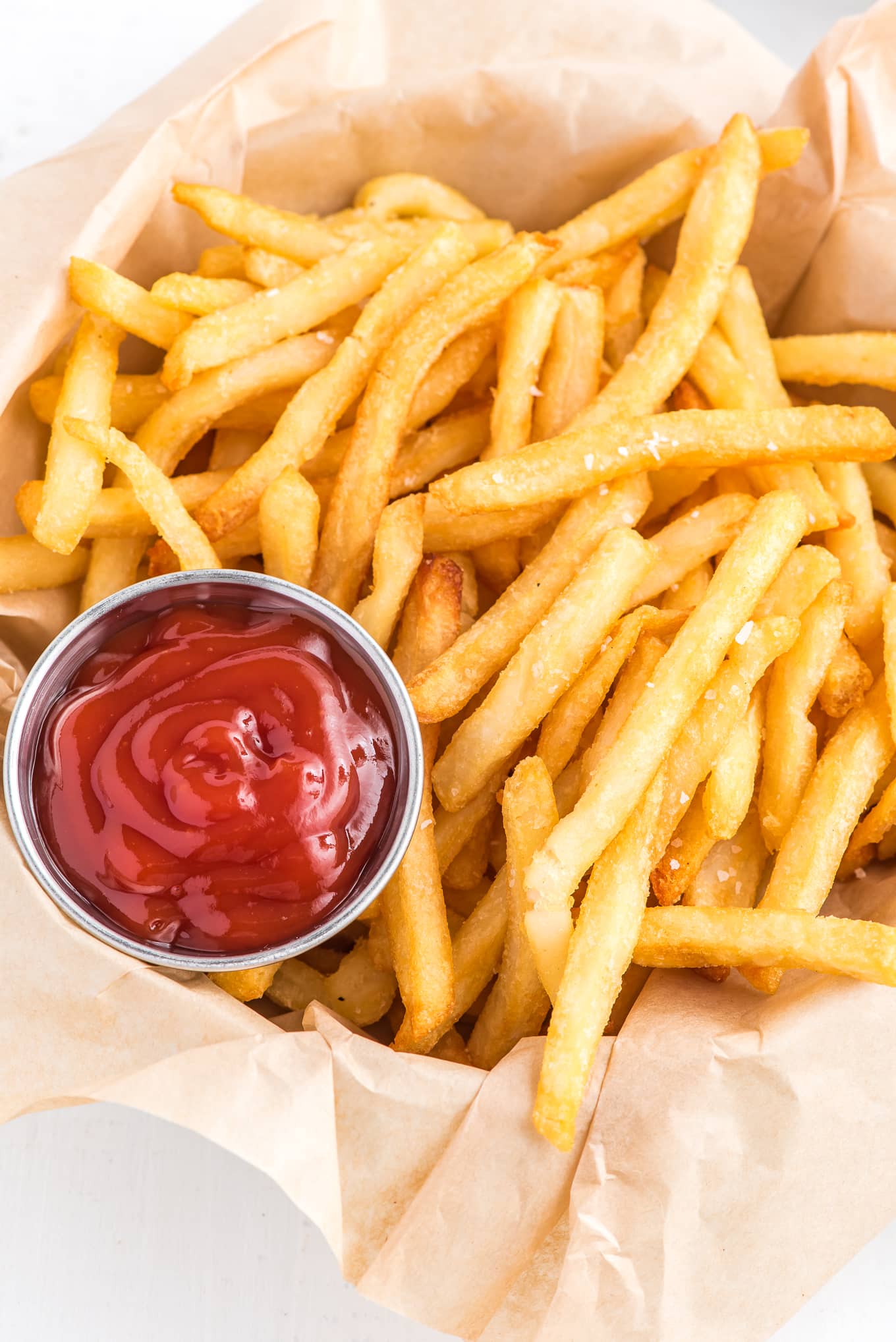basket of frozen french fries cooked in the air fryer. / Enjoy crispy and delicious frozen French fries in minutes with this easy air fryer recipe. Get that classic crispy texture and savory flavor you love, with the convenience of the air fryer.