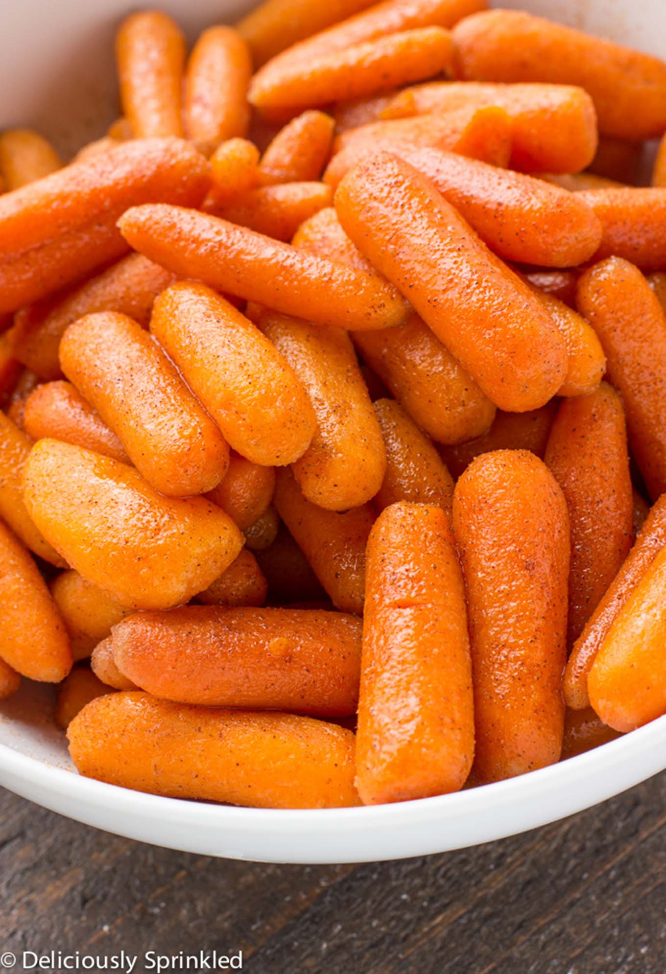 Instant Pot Glazed Carrots in a white bowl/ Brown sugar carrots only use simple ingredients and only takes less than 10 minutes to make. Perfect holiday side dish that everyone will love. 