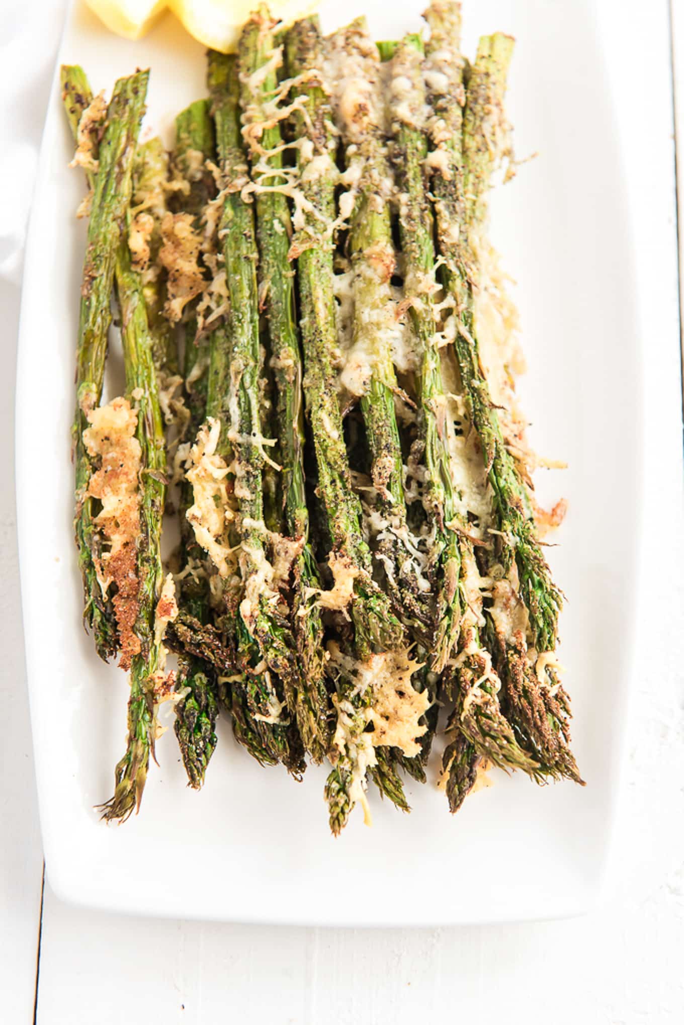 Air fryer asparagus seasoned and cooked on a plate. 