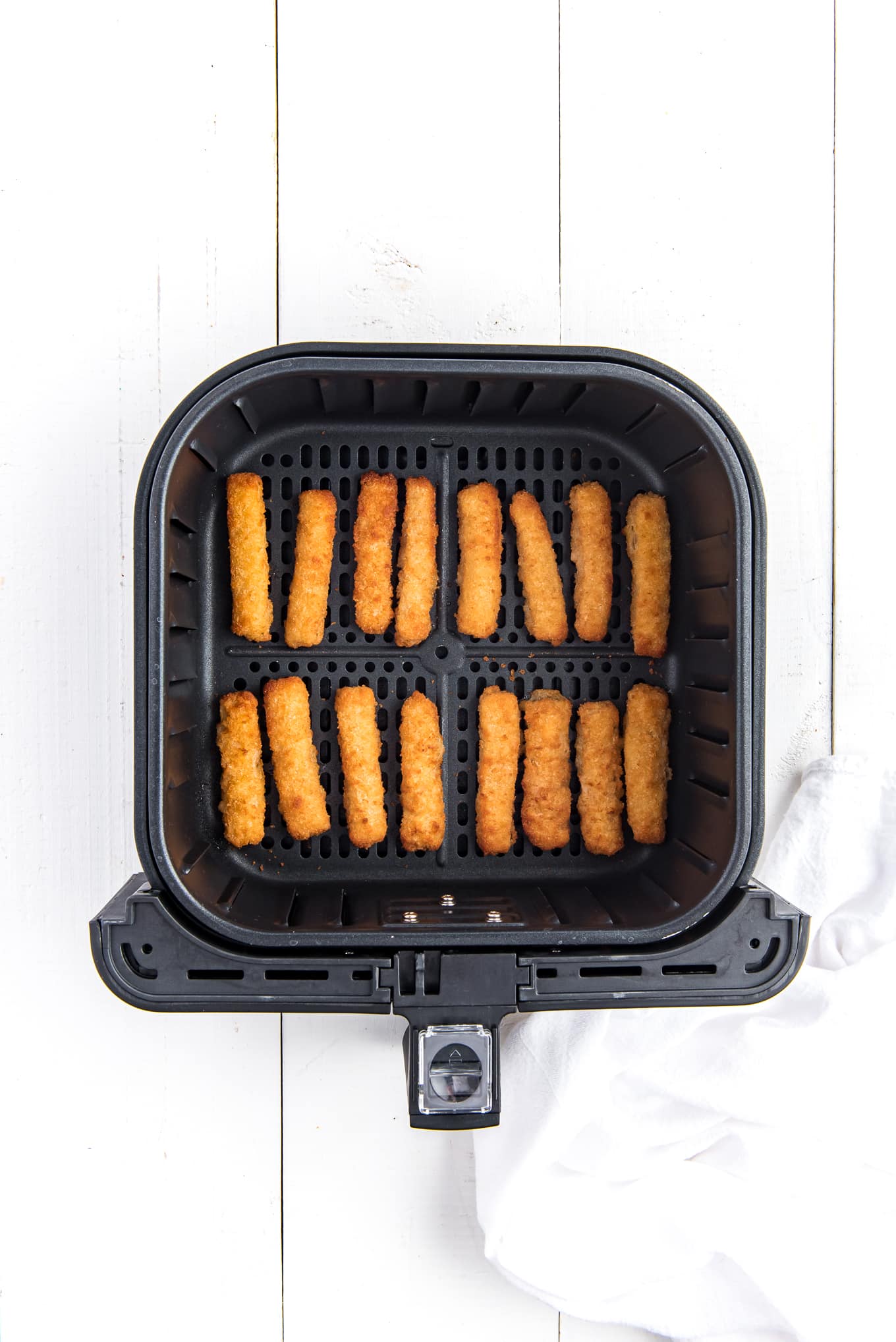 Overhead image of fish sticks lined in the air fryer basket.