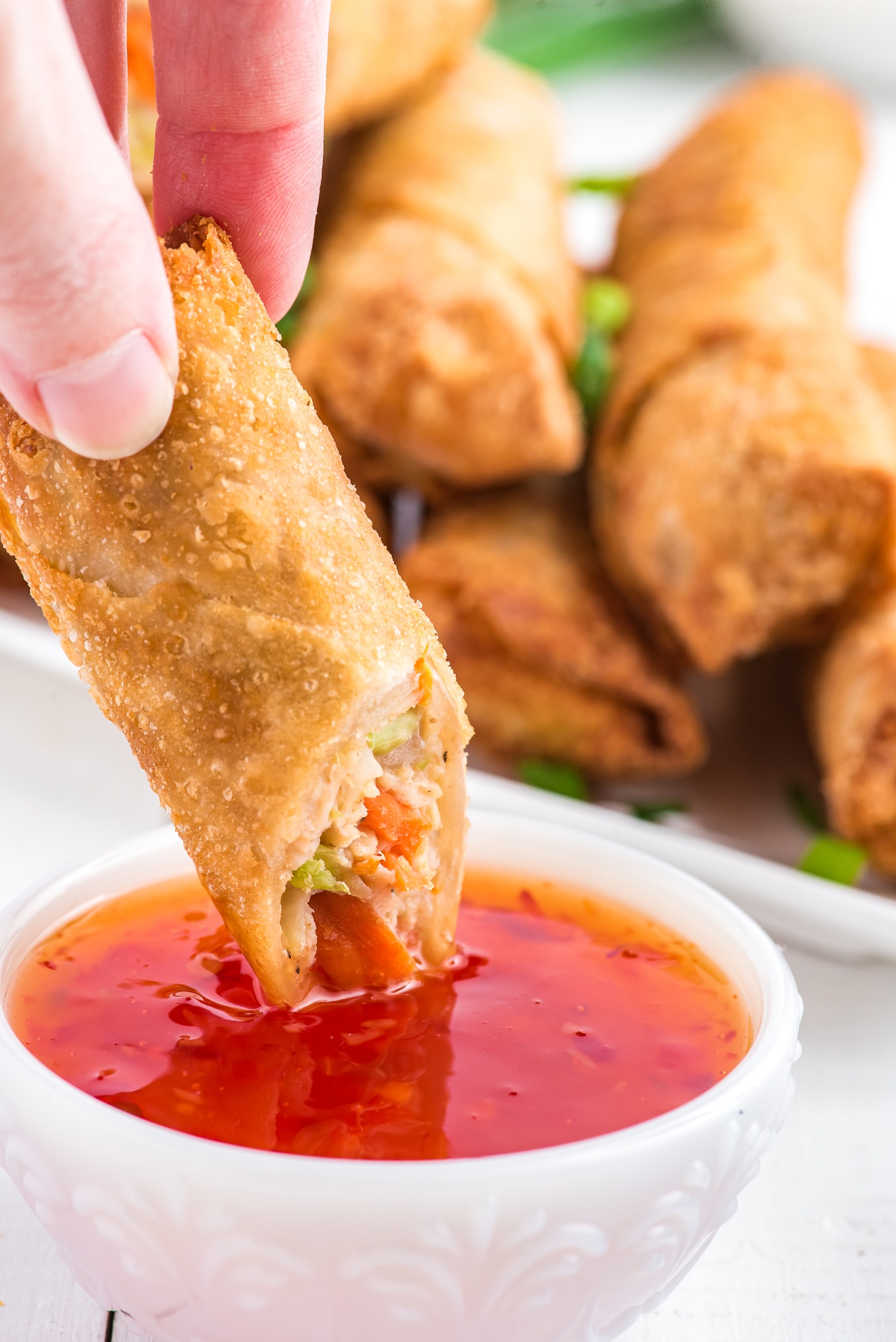 Dipping an air fried egg roll in sweet chili sauce. 