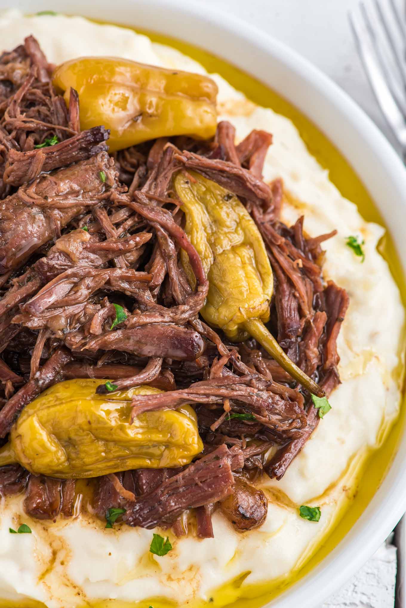 Mississippi pot roast on a plate with pepperoncini peppers.