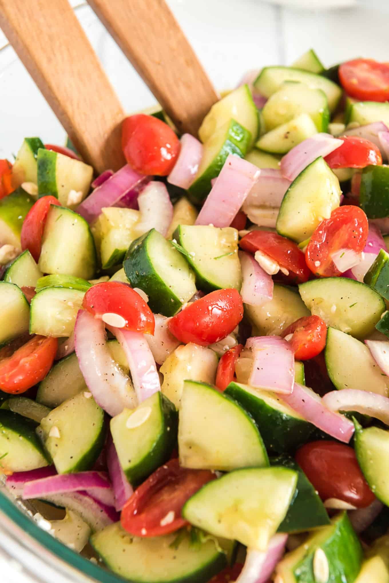A closeup of cucumber tomato and onion salad in a bowl.