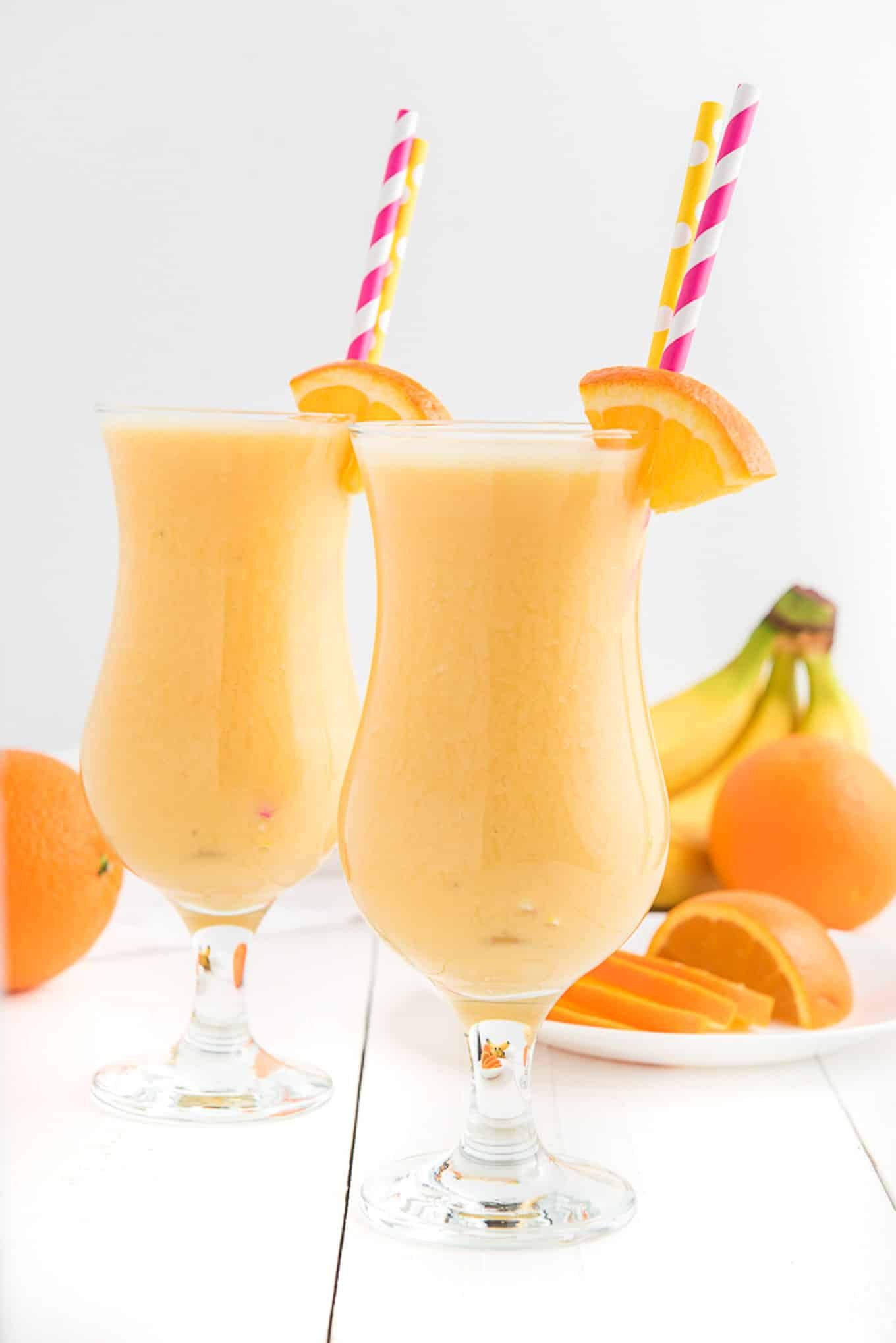 Two glasses of orange smoothie side by side. 