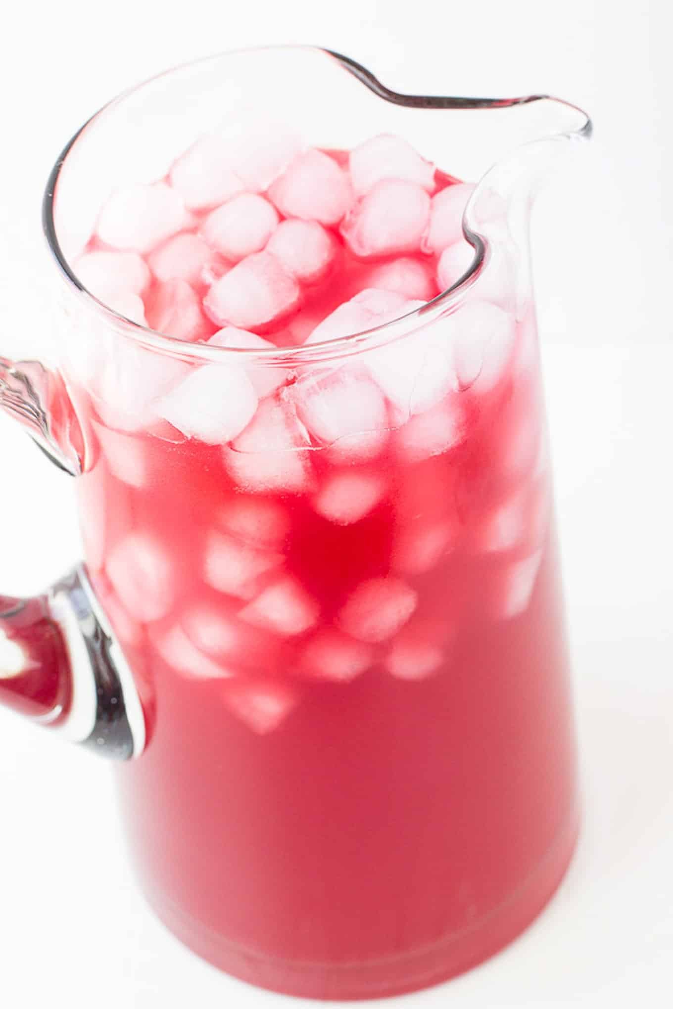 A tall pitcher with party punch and ice.