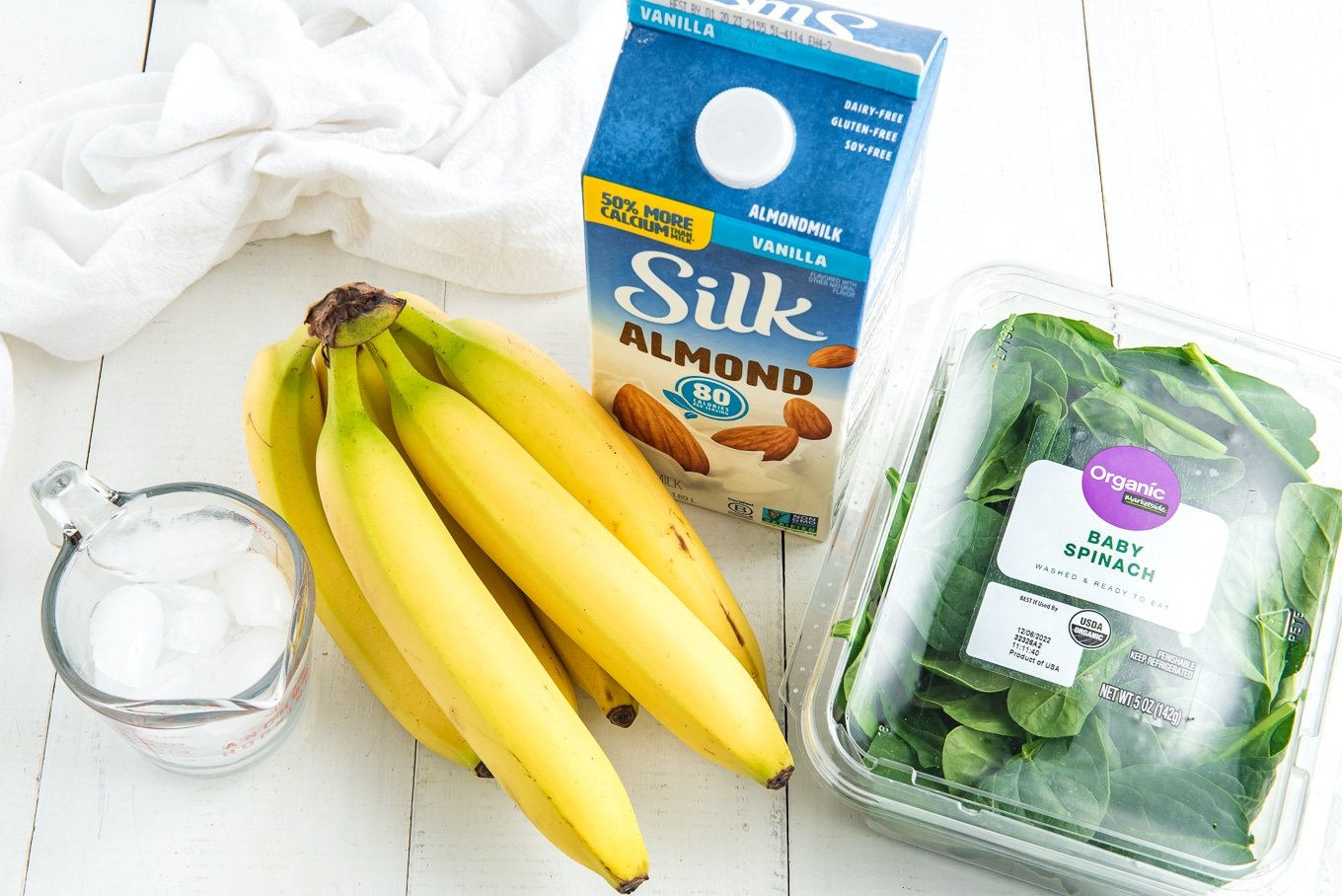 Ingredients to make a spinach banana smoothie on the table.