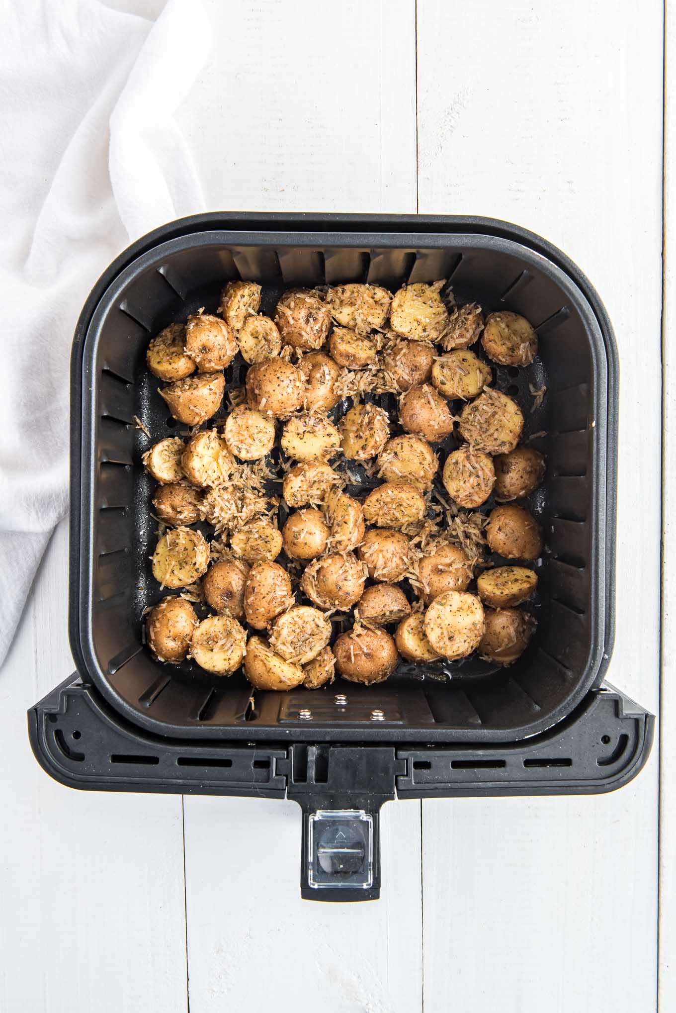 Small potatoes in air fryer basket ready to cook.