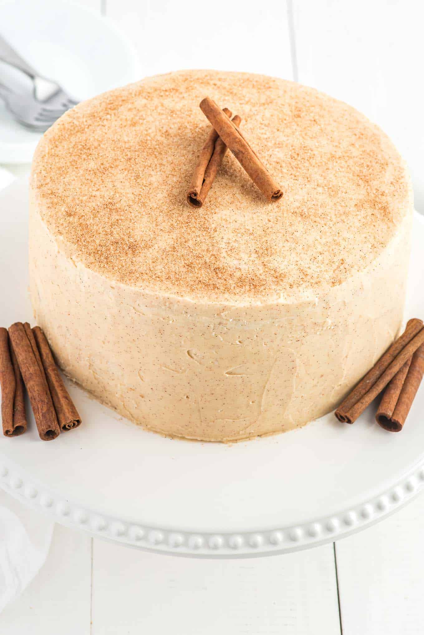 cinnamon cake with cinnamon buttercream frosting on a plate. 