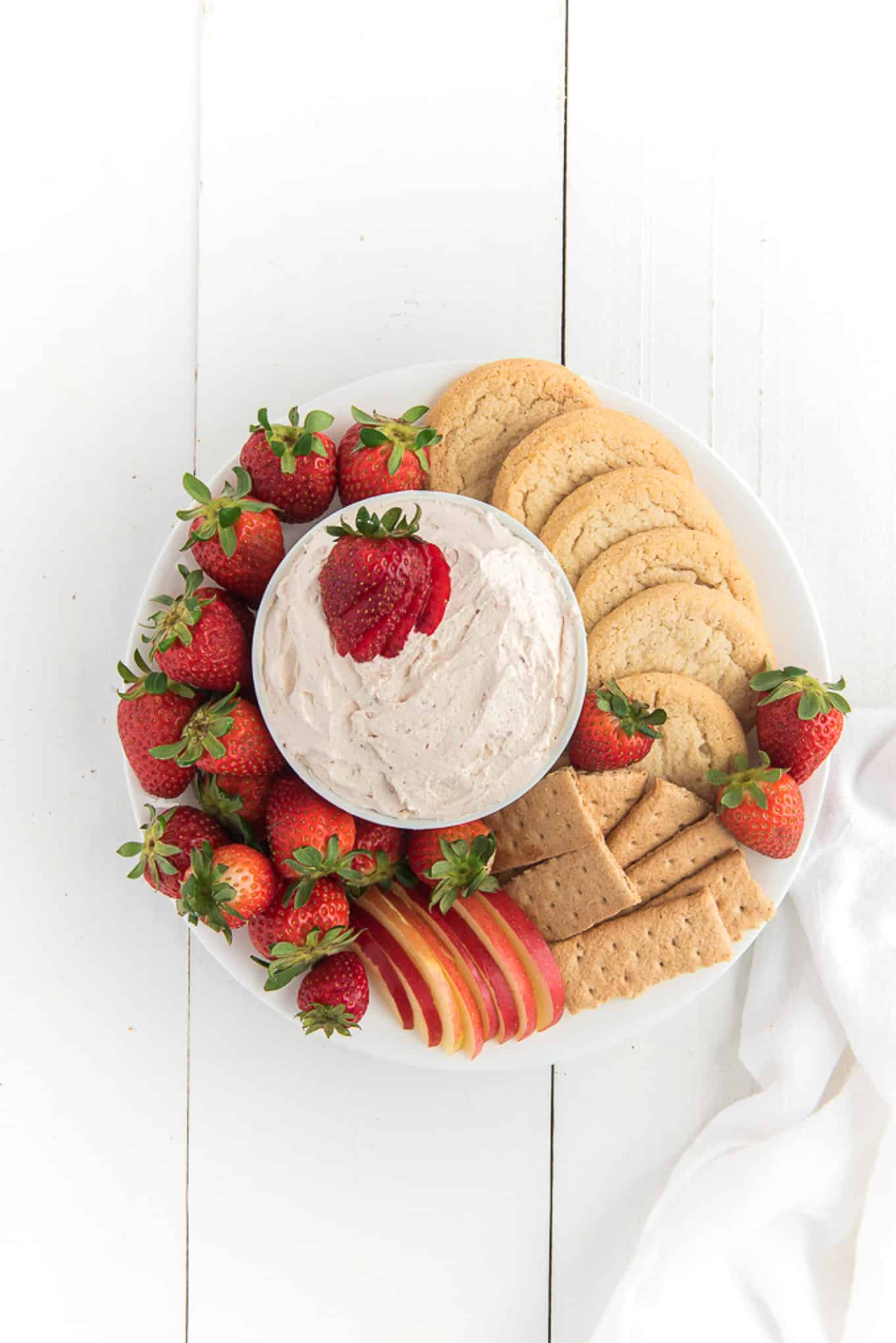 Above shot of fruit dip with cream cheese surrounded by fruit and graham crackers.
