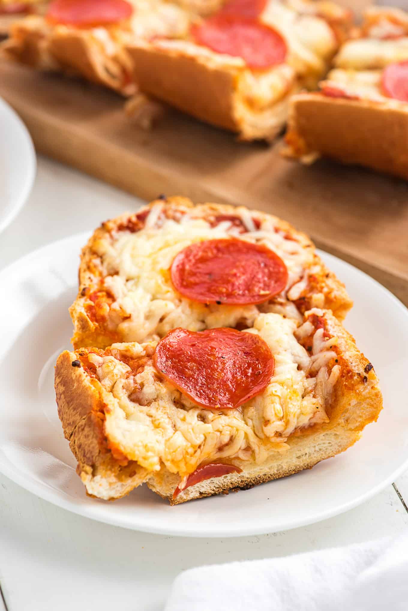 Slices of pizza on a plate made from french bread.