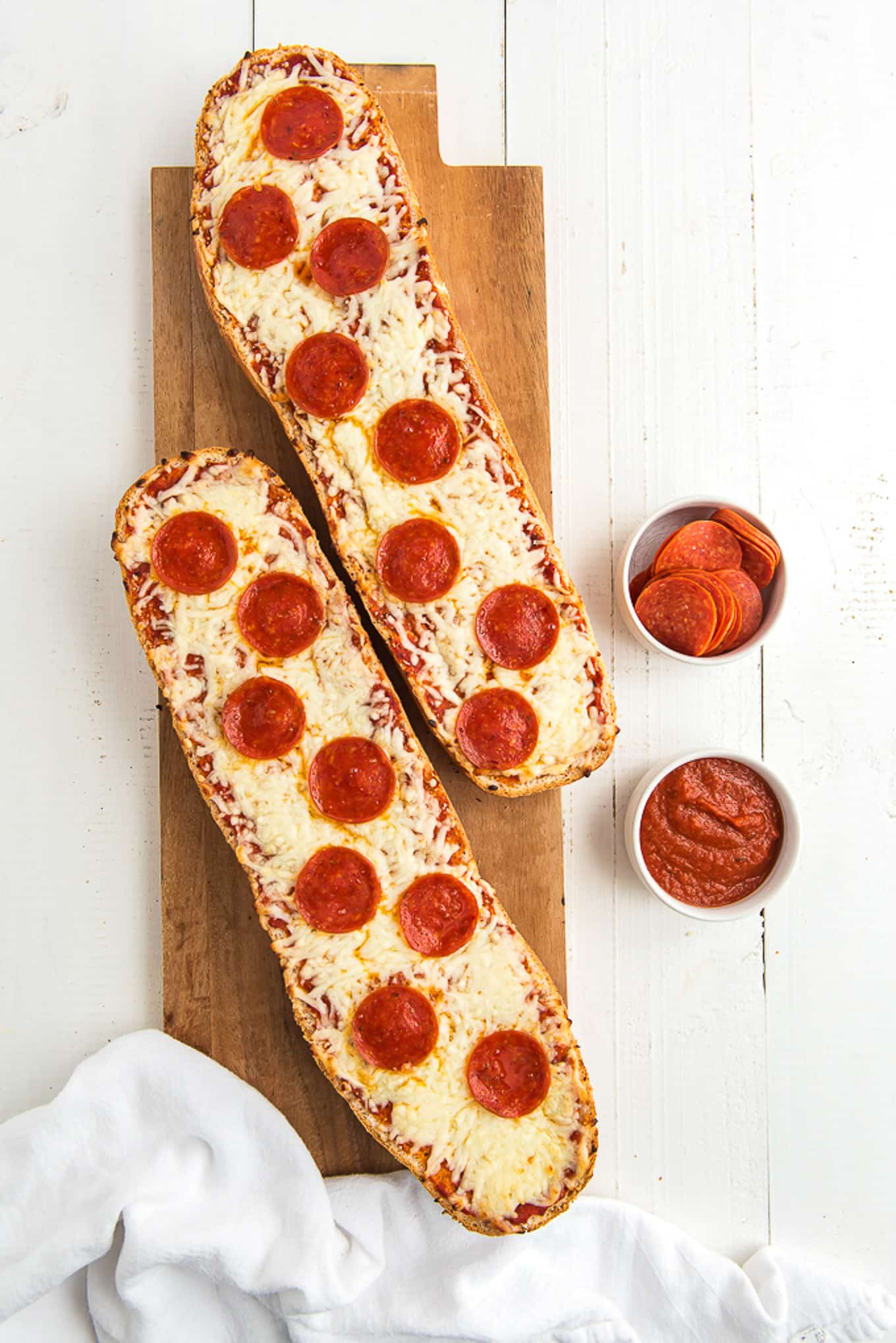 Cooked french bread halves with pizza toppings.