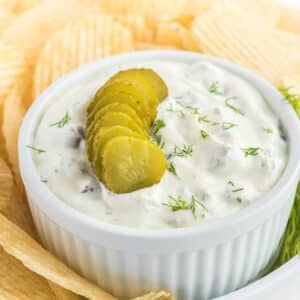 Tasty pickle dip surrounded by potato chips.