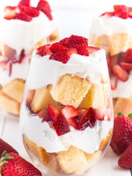 A pinterest pin for strawberry shortcake cups with a side shot of the cups in wine glasses.
