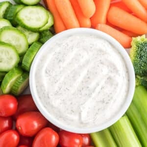 An above shot of veggie dip surrounded by vegetables.
