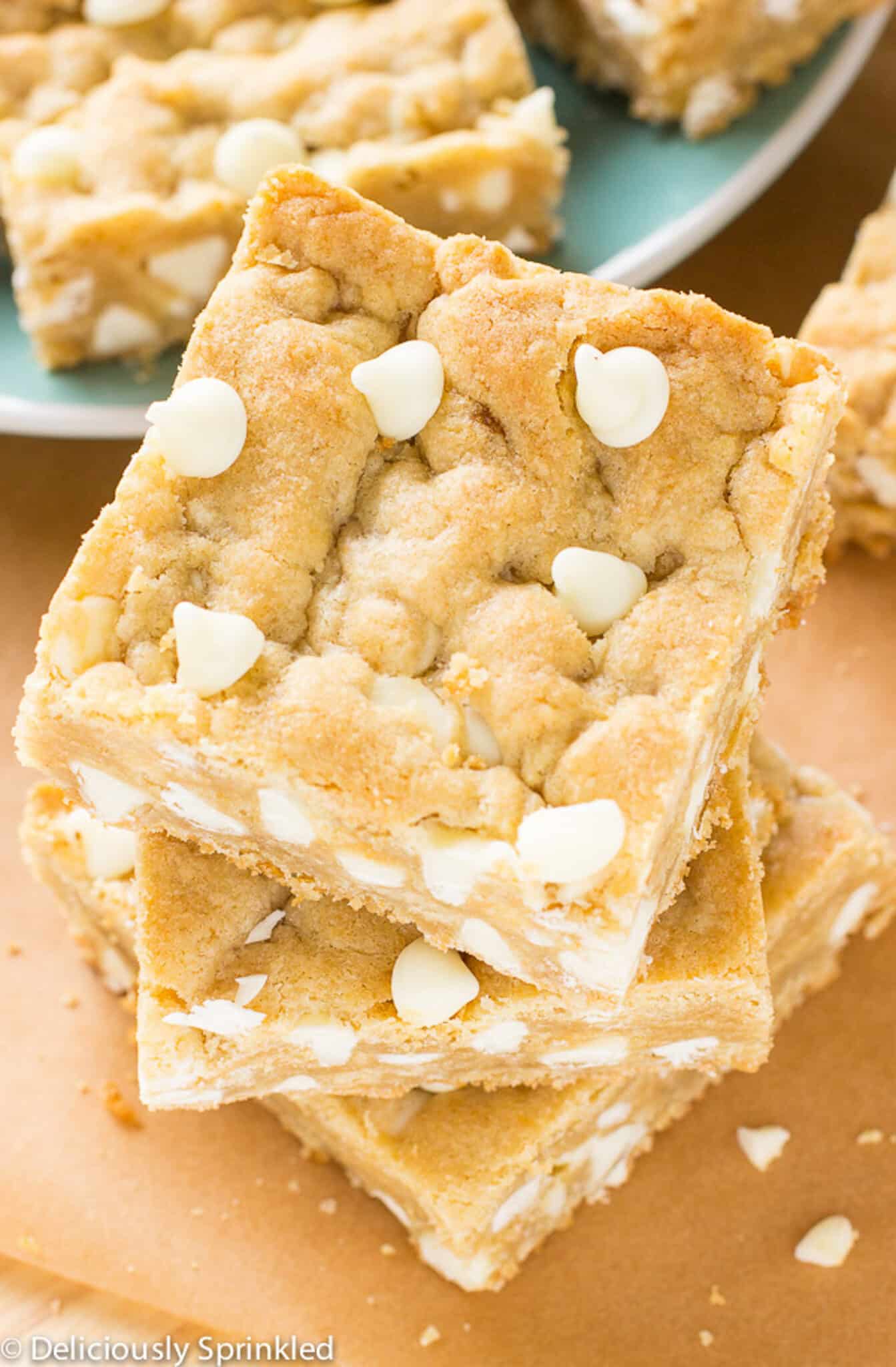 A stack of three blondies with white chocolate chips on the table.