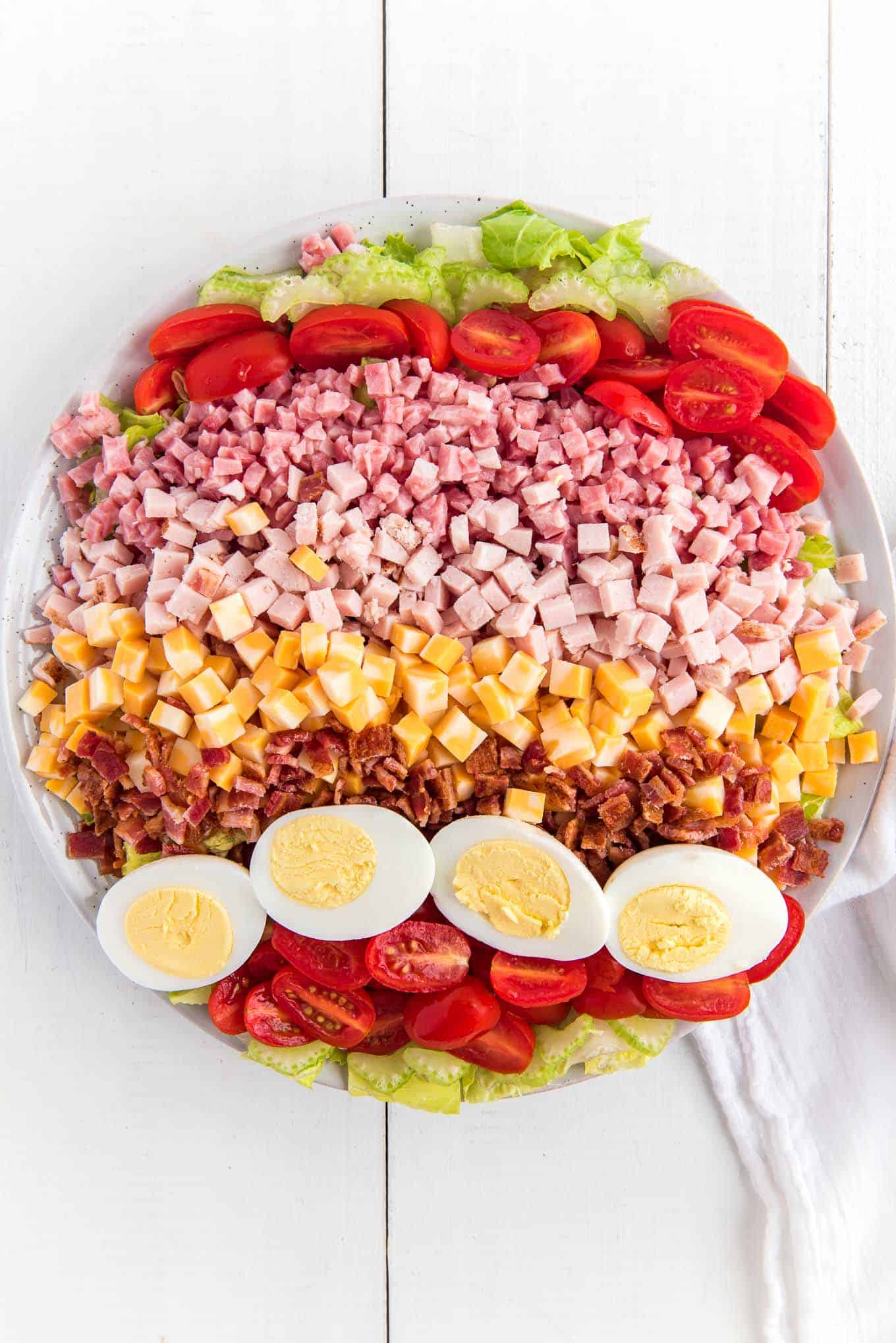 A Chef salad on a white platter on the table.