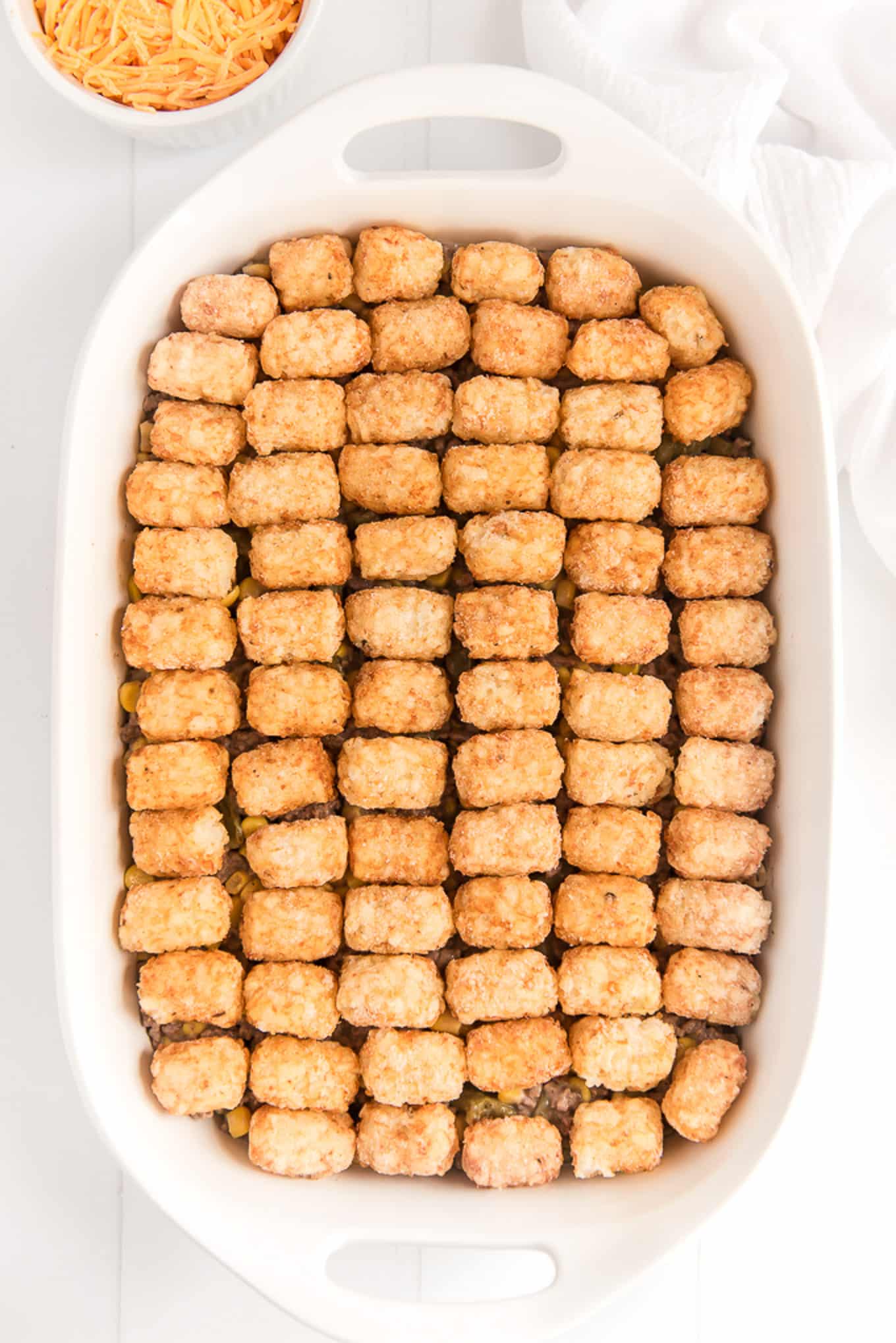Tater tot casserole with tots layered on top of the ground beef mixture. 