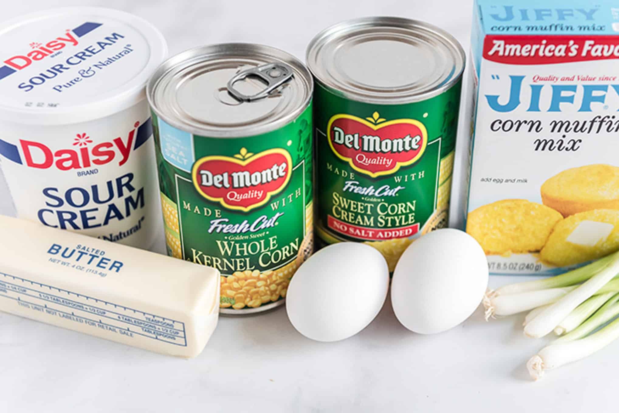 Ingredients to make corn casserole with Jiffy on the counter. 